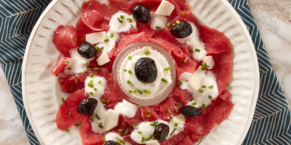 Carpaccio picnic with baked olives and yoghurt and chives sauce